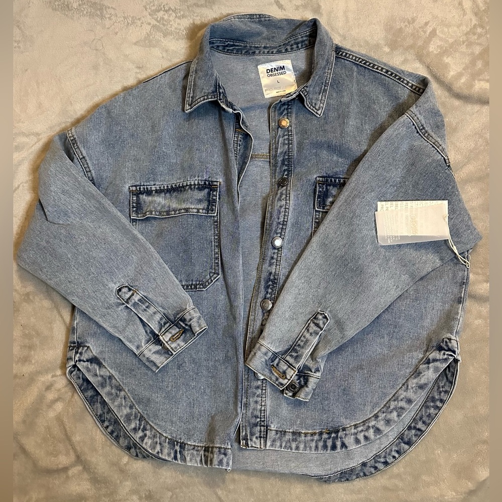 Oversized blue denim jacket with a relaxed fit and a button-up front.